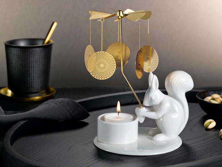 Teelichtkarussell mit Eichhörnchen hält ein Teelicht auf einem eleganten Tisch.
