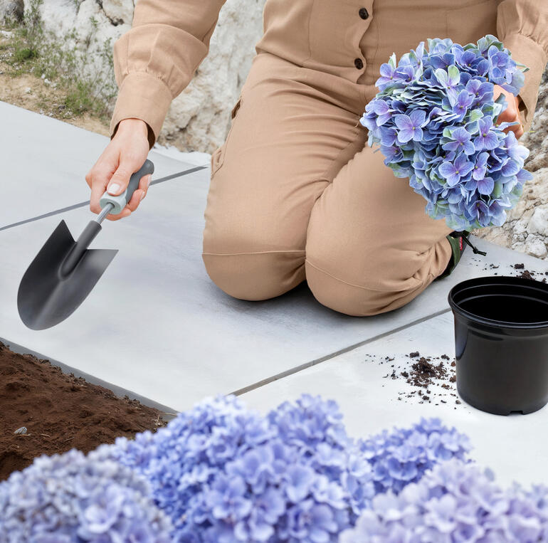 Verstärkte Knie inkl. Polsterung für komfortables Arbeiten. Detailansicht von Blumen in den Händen einer Frau.