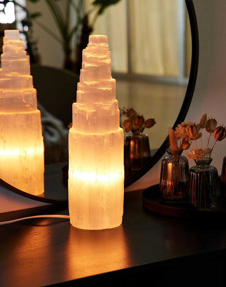 Selenit-Lampe leuchtet sanft auf einem Tisch.