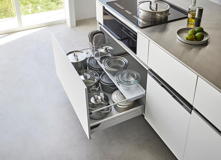 Schubladeneinsatz schwarz mit Töpfen in einer geöffneten Küchenschublade