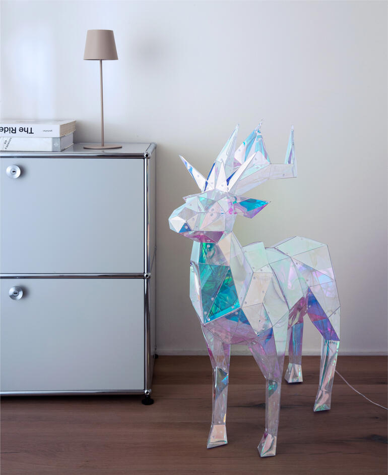 Schillernder Hirsch im modernen Innenraum mit Lampe und Wohnmöbel.
