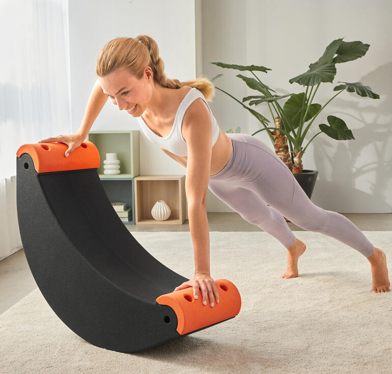 Frau trainiert auf einem 3-in-1 Multifunktions-Trainer mit orangefarbenen Griffen.