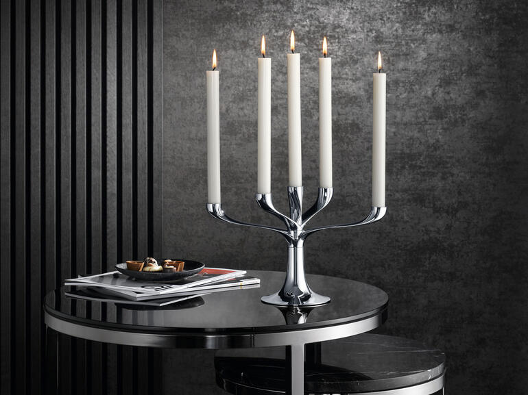 Moderner Kerzenleuchter mit fünf Kerzen auf einem Tisch, elegante Dekoration.
