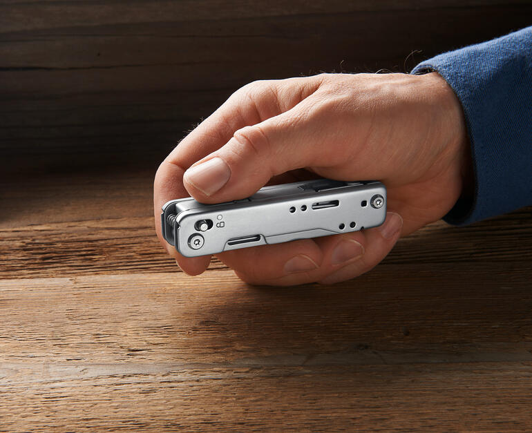 Hand hält kompaktes Multitool 12-in-1 mit geschlossenen Werkzeugen.