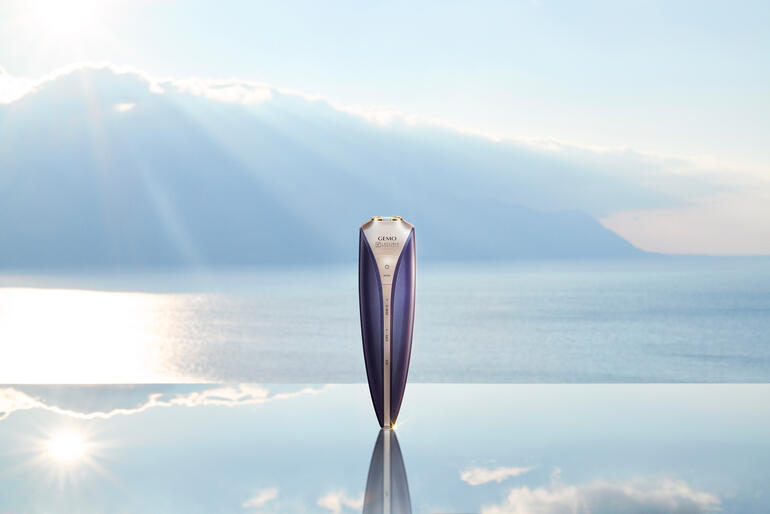Anti-Aging-Gerät steht auf einem Tisch mit Berglandschaft im Hintergrund.