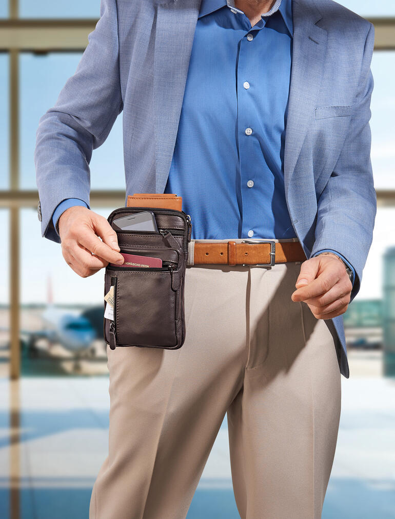 Mann mit farblich abgestimmter Gürteltasche aus Büffelleder, die er an seinem Gürtel hält.