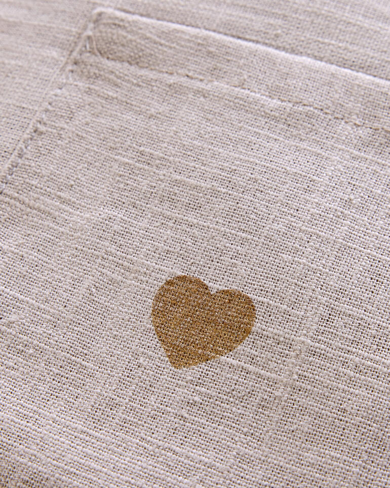 Detailansicht des Stoffes des Schulterwärmers mit Herzmotiv