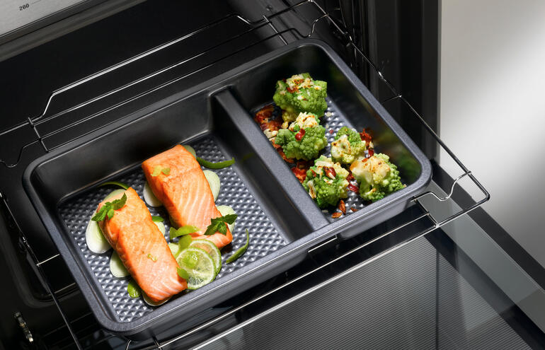 Zwei-geteilte Ofenform mit Lachs und Gemüse im Backofen