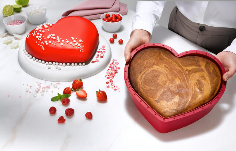 Silikonbackform in Herzform gehalten von einer Person