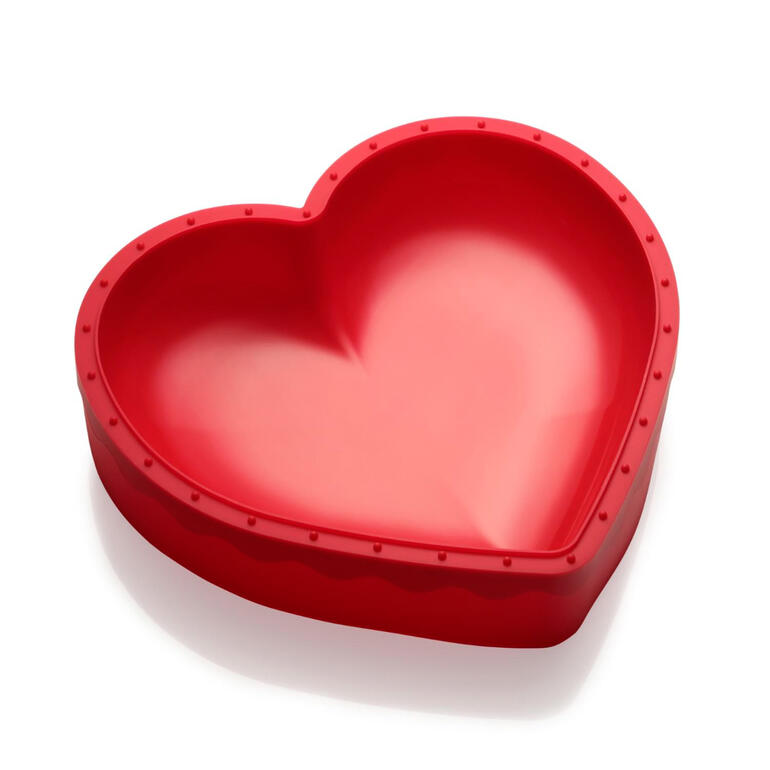 Rote Silikonbackform in Herzform auf einem weißen Hintergrund.