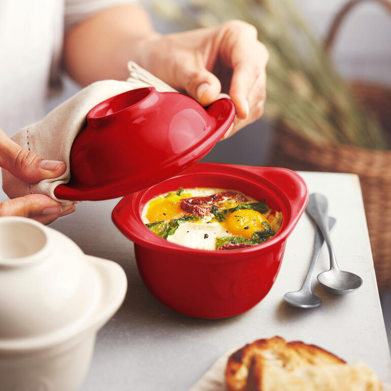 Roter Egg Coddler in den Händen einer Person, die ihn öffnet.