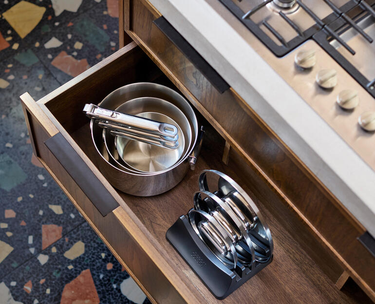 Kochgeschirrset mit Klappgriffen in einer Küchenschublade, sichtbare Töpfe und Deckel.