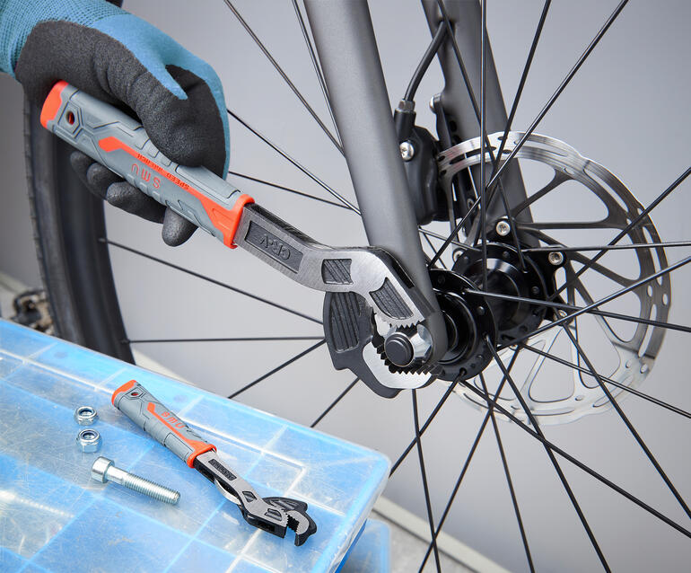 Schnellspann-Schlüssel wird zur Wartung eines Fahrradbremsmechanismus genutzt.