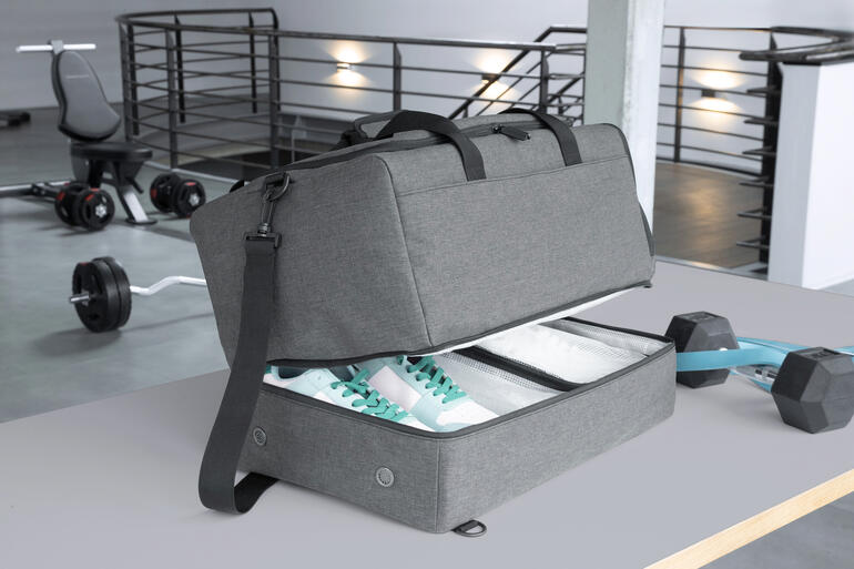 Graue 2-in-1 Allroundtasche mit offenem Reißverschluss, gefüllt mit Sportschuhen.