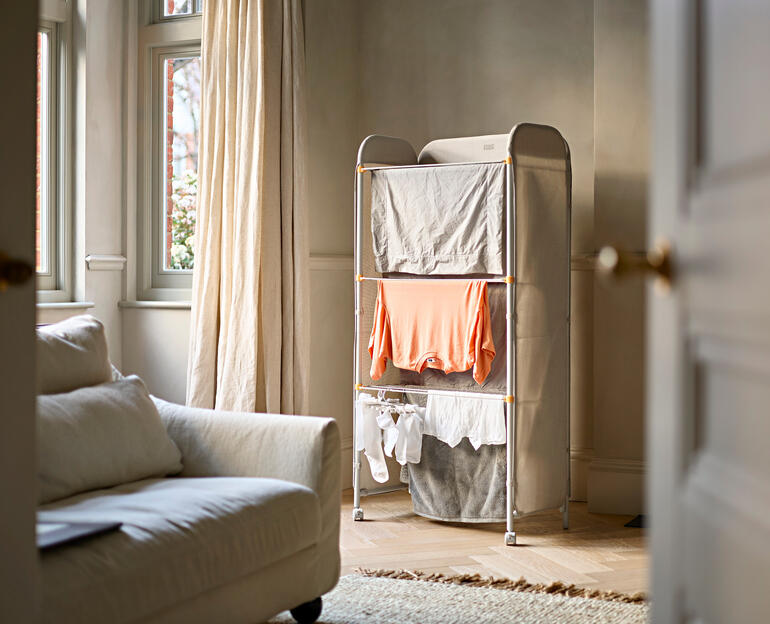 Wäscheständer Paravent mit aufgehängter Kleidung im Raum.