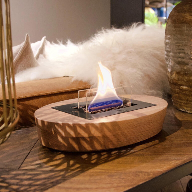 Eiche-Tischkamin auf einem Tisch, dekorativ mit sichtbarer Flamme.