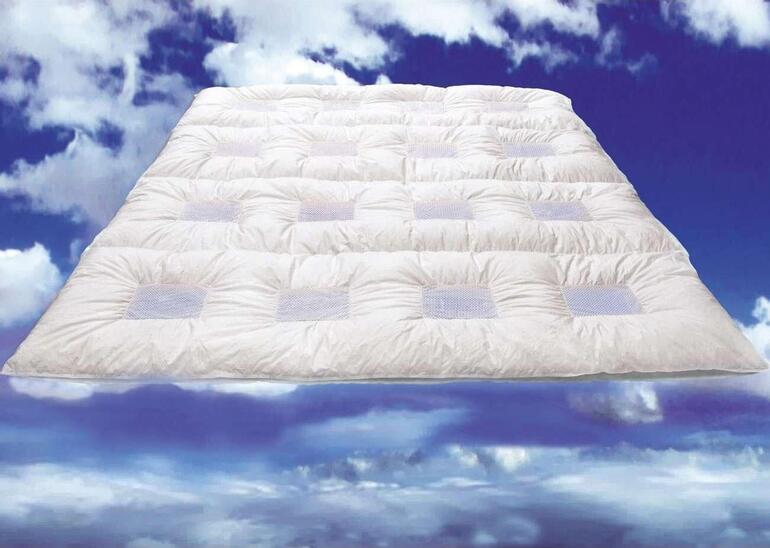 ClimaBalance Daunendecke in Wolken auf blauem Hintergrund.