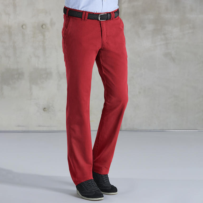 Mann in roter Fein-Canvas-Hose vor grauer Wand