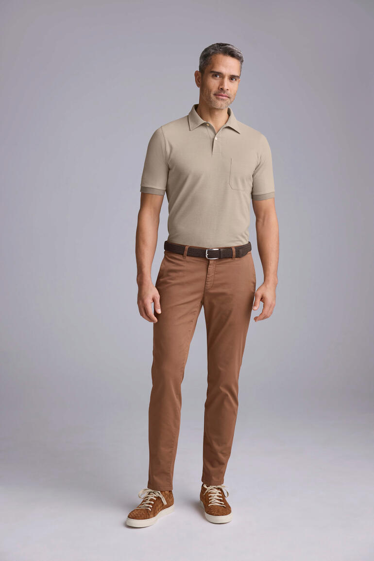 Braun Mann in beigem Pima-Cotton Shirt mit neutralem Hintergrund.