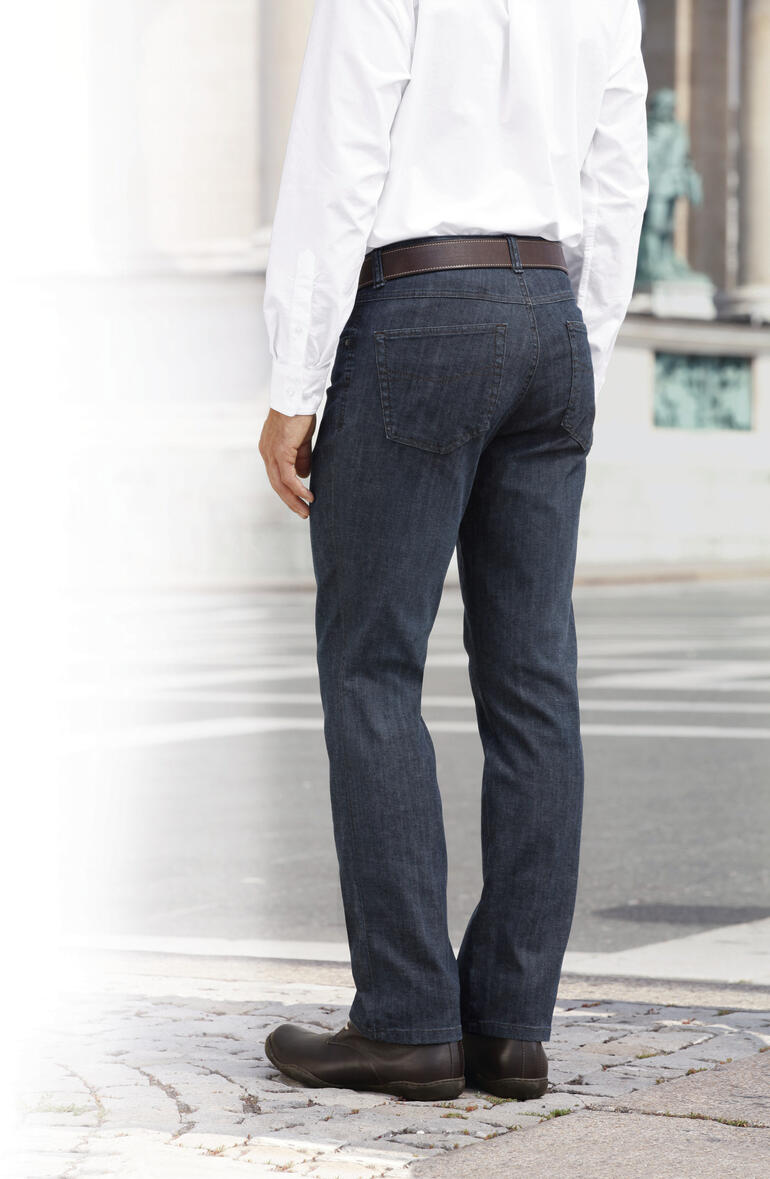 Mann steht in einem weißen Badezimmermantel aus Doppelgewebe.