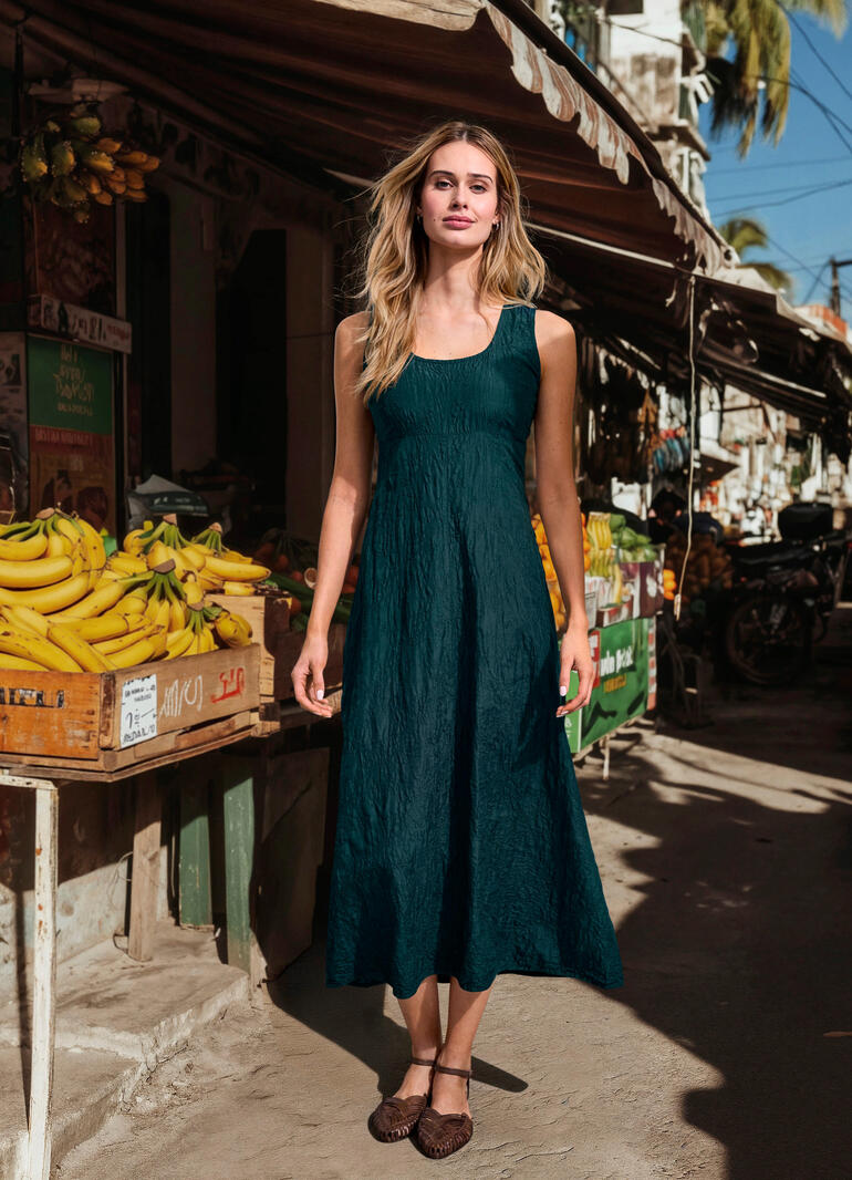 Besticktes Seidencrash-Kleid Frau in sticktem grünem Seidencrash-Kleid vor einem Markt.