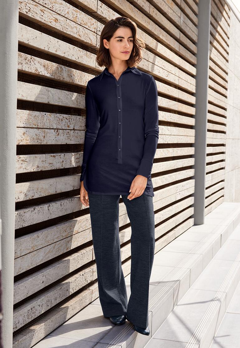 Navy Lange Tencel-Bluse in Dunkelblau, im Freien an einer Wand gelehnt.