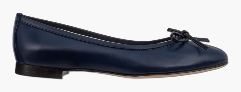 Ballerina in Navy mit Schleife, seitliche Ansicht.