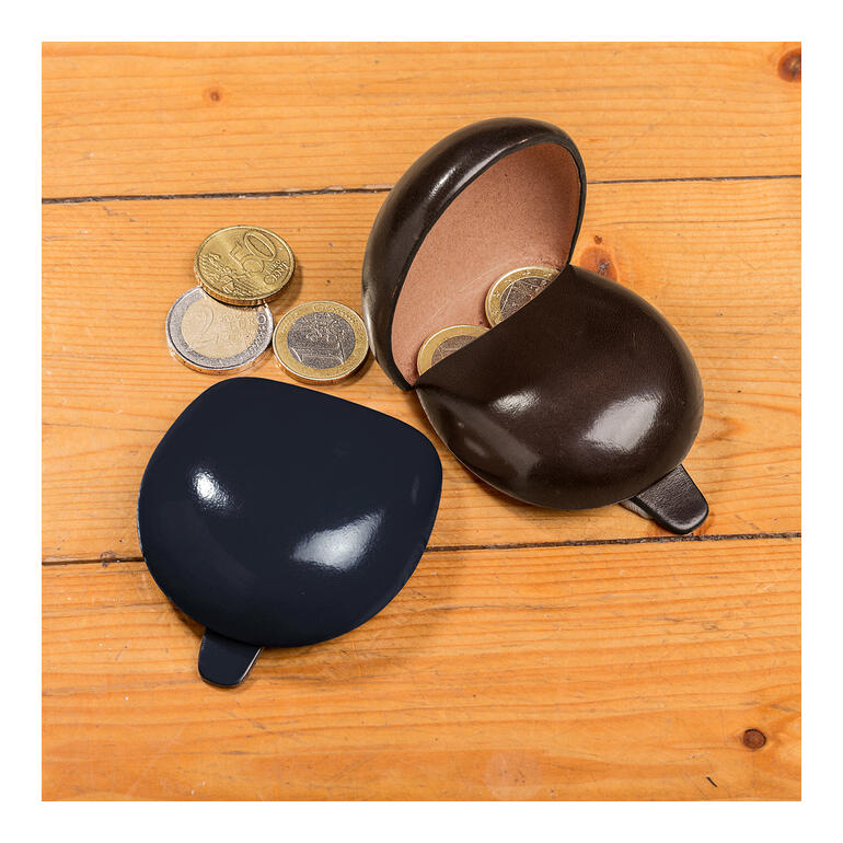 Zwei runde Leder-Münzhalter in Schwarz und Dunkelbraun auf Holzuntergrund.