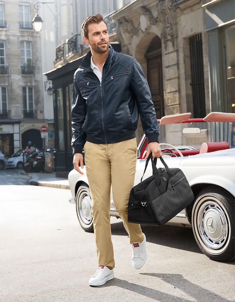 OCONI Sommer-Lederblouson Mann trägt blauen Sommer-Lederblouson und beige Hose auf der Straße.