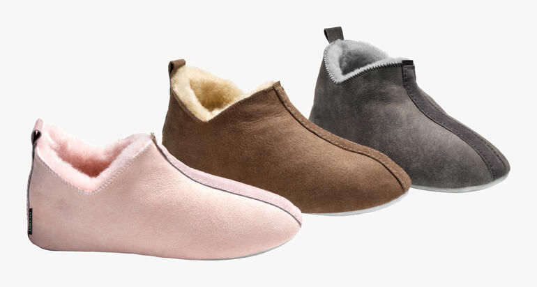 Drei Paare Lammfell-Slip-Ons in verschiedenen Farben: Rosa, Braun und Grau.