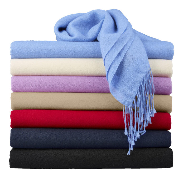 Bunt gestapelte Pashmina-Schals mit blauem Schal obendrauf.