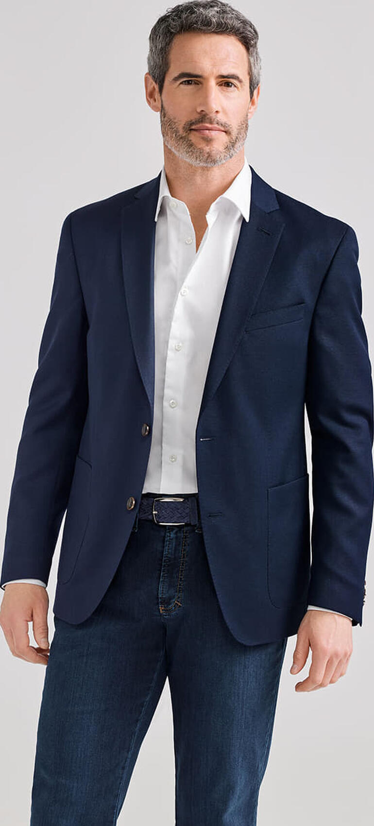 Blau Mann in dunklem Reiscolbert mit weißem Hemd, lässige Pose.