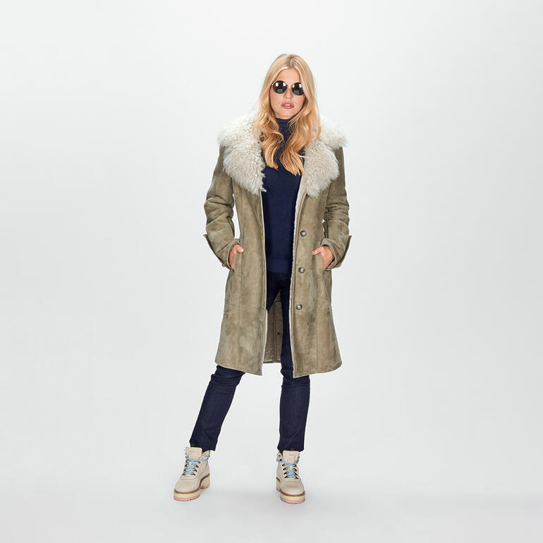 Frau in olivgrünem Lammfellmantel mit hellem Kragen