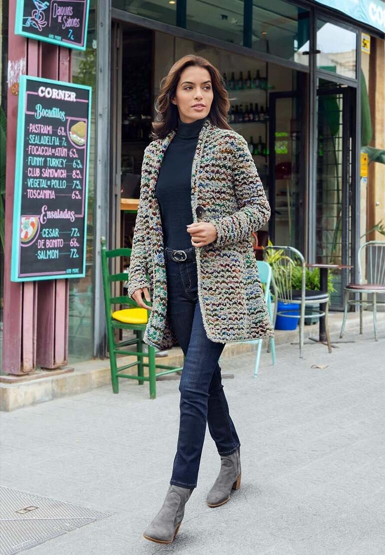 Frau in buntem handgestricktem Longcardigan auf der Straße