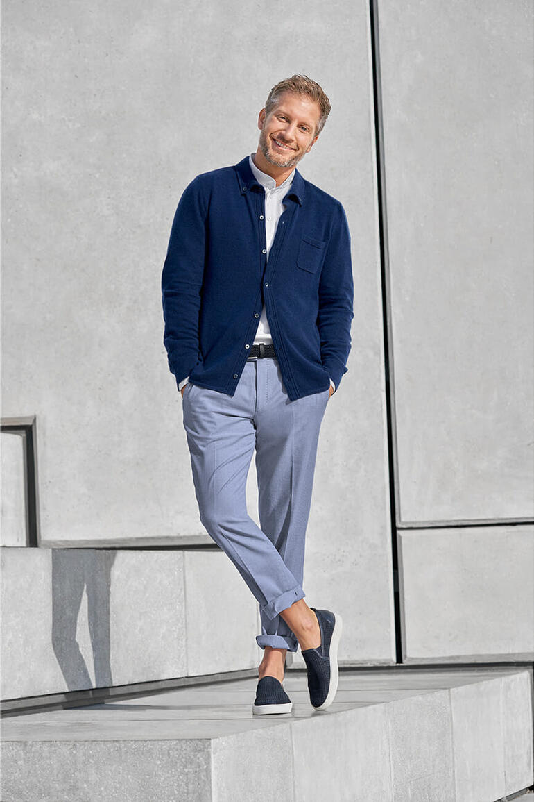 Hiltl Oxford-Hose Mann in navy Feinstrick-Hemd mit Tasche steht auf Stufen
