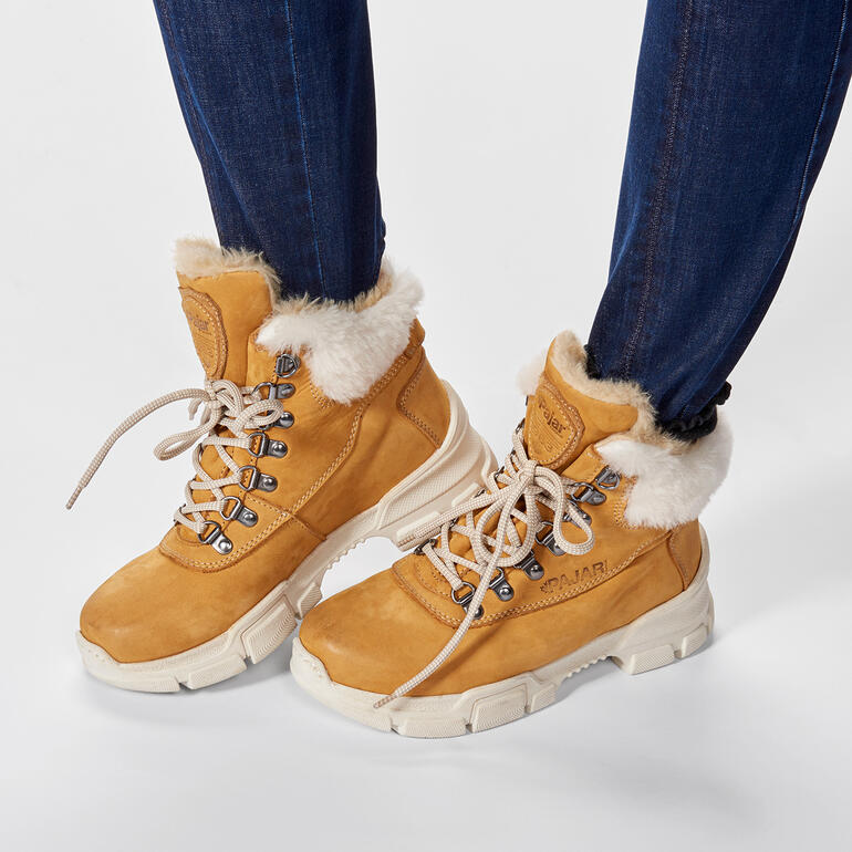 Braune Wanderschuhe mit Fellkragen, getragen von einer Frau