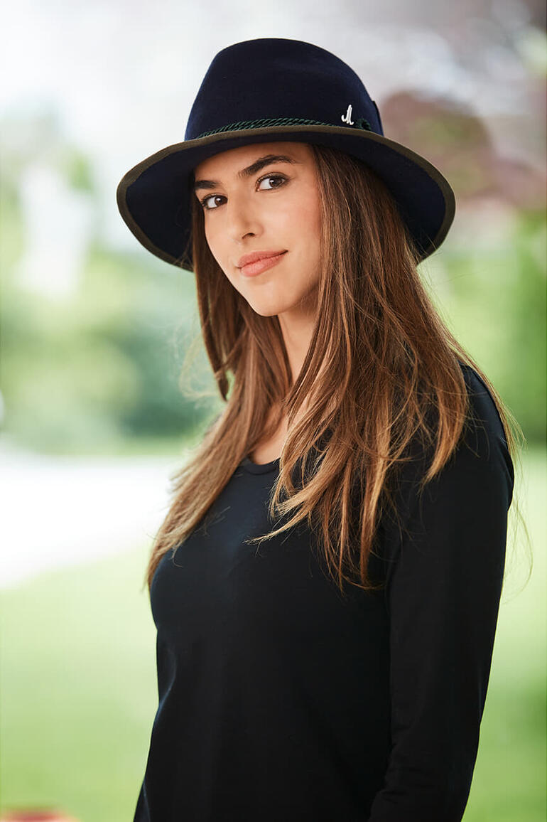 Seitenansicht einer Frau mit marineblauem Filzhut.