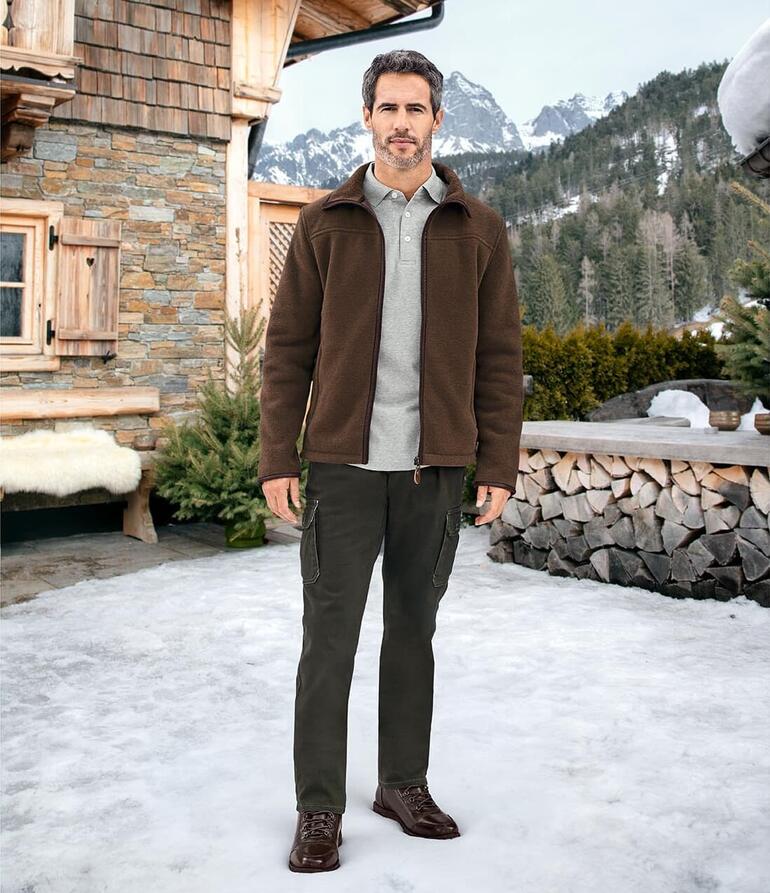 Mann in Polartec Fleece-Jacke steht in schneebedeckter Umgebung