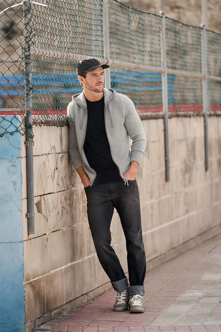 Grey-Denim-Jeans, ein Mann in lässigem Outfit an einer Mauer.