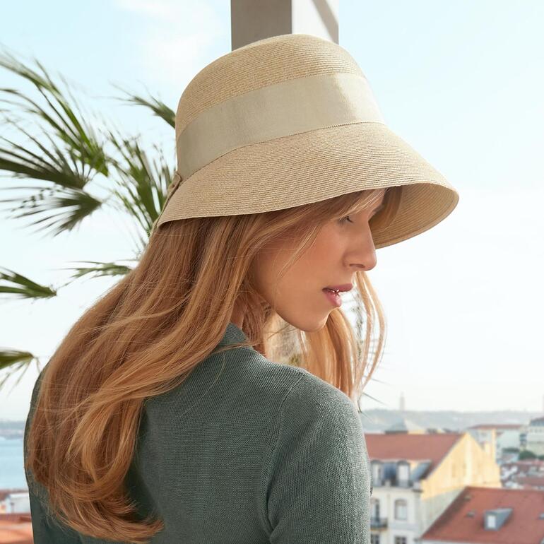 Loevenich Borten-Sommerhut Frau trägt einen beigefarbenen Borten-Sommerhut in städtischer Umgebung