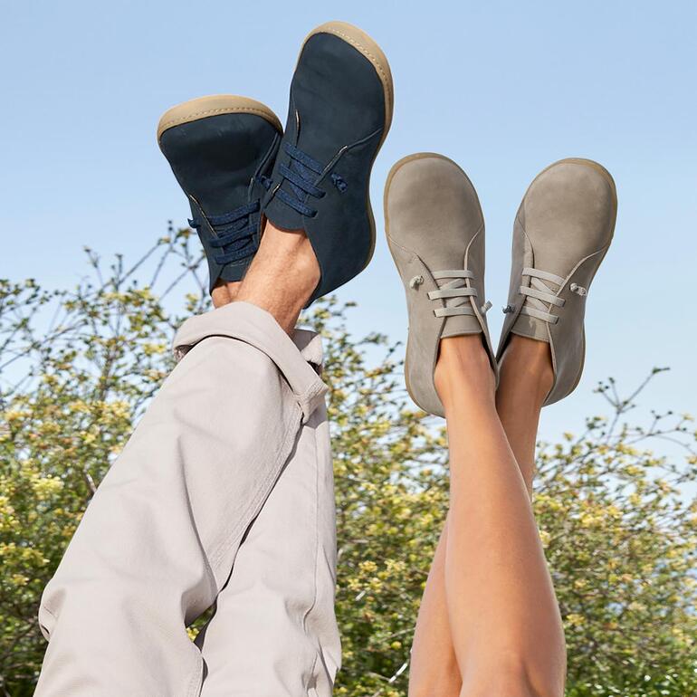 Herren, Navy und Damen, Beige Füße in schwarzen und grauen Snipe® Barfuß-Lederschuhen, lässiger Hintergrund