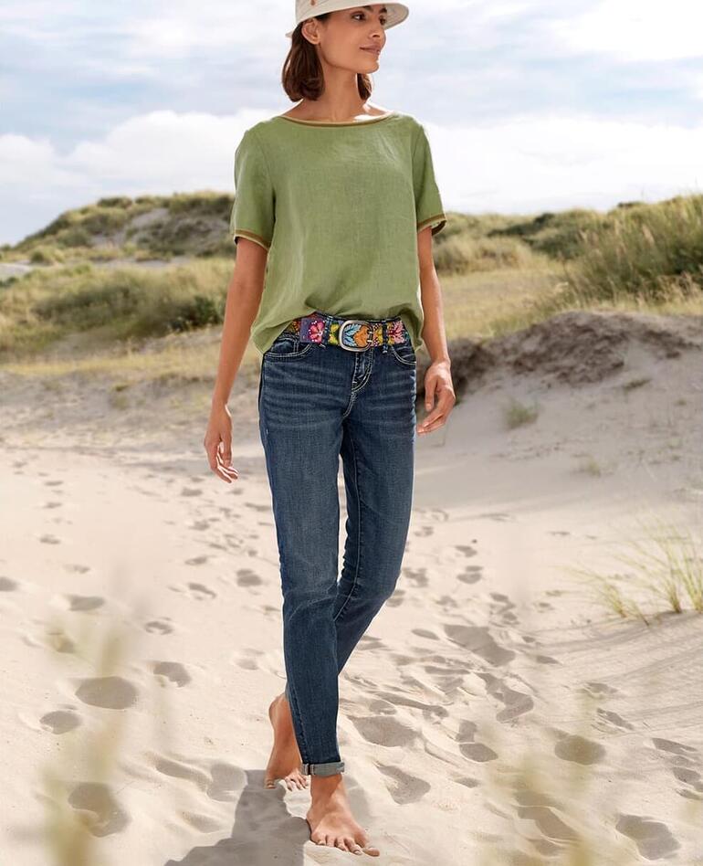 Frau trägt La Feé Maraboutée Leinen-Shirt in Olivgrün am Strand