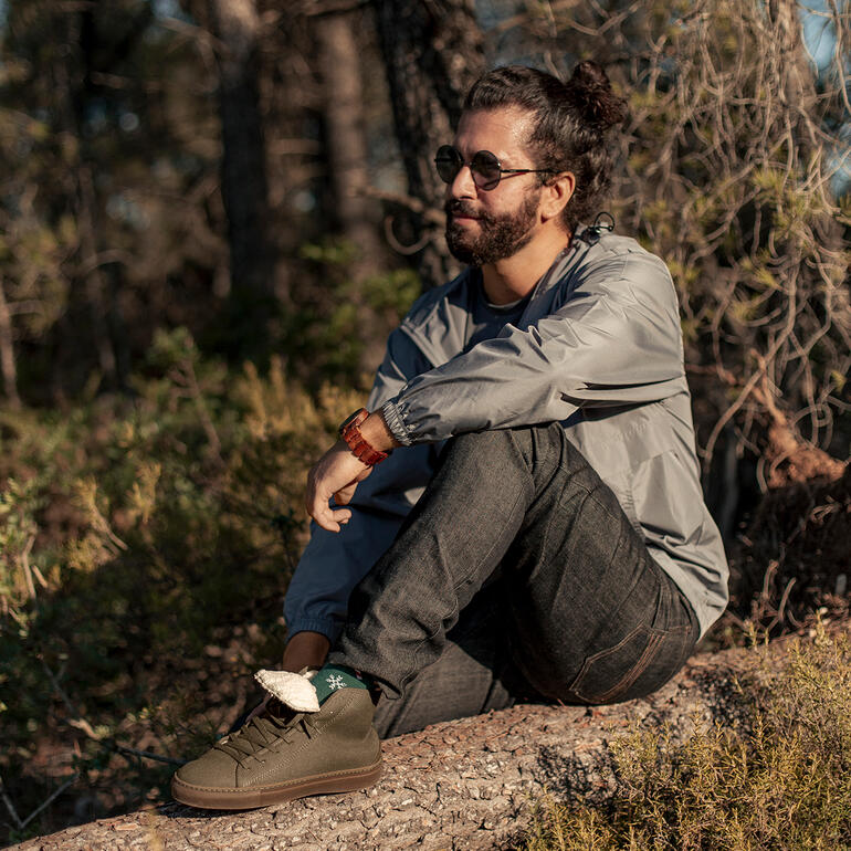 Khaki Winter-Canvas-Sneaker an einem Mann beim Sitzen auf einem Baumstamm