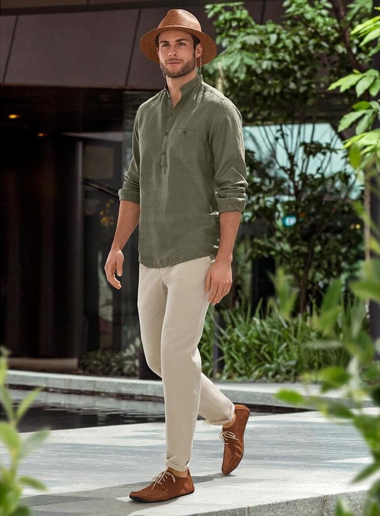 Sole Runner® Ledermokassin Mann in Ledermokassins mit lässigem Outfit steht in einer grünen Umgebung.