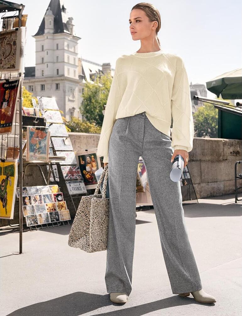 Grau meliert Frau trägt Junghans Basket-Pullover mit grauem Hosen und Stofftasche.