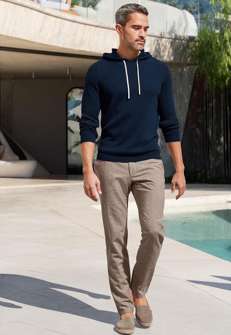Herren, Navy Pima-Rippstrick-Hoodie in Dunkelblau, kombiniert mit beigen Hosen.