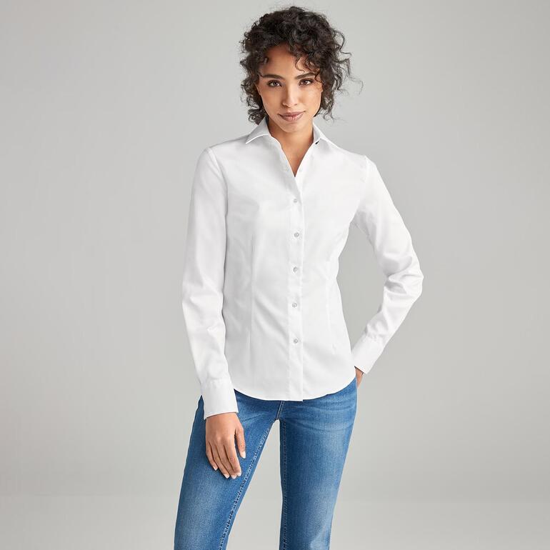 Frau trägt eine weiße QuickClean-Bluse mit aufgestellten Kragen und Knöpfen.