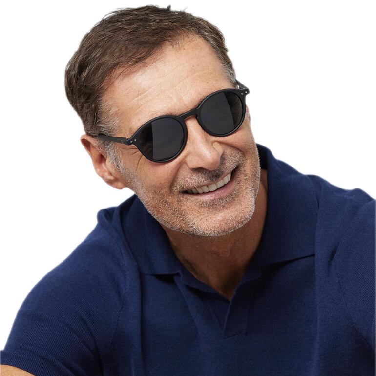 Sonnenbrille, Schwarz Mann mit Sonnenbrille lächelt, trägt einen dunkelblauen Poloshirt.
