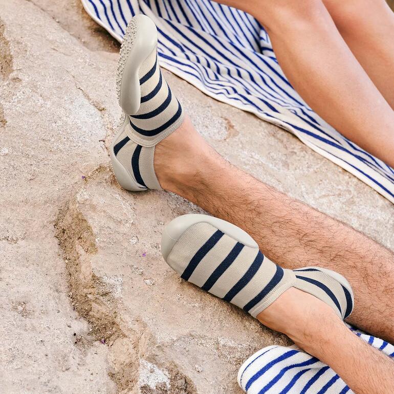 Beige/Navy Gestreifte Sommer-Haussocken in sandiger Umgebung.