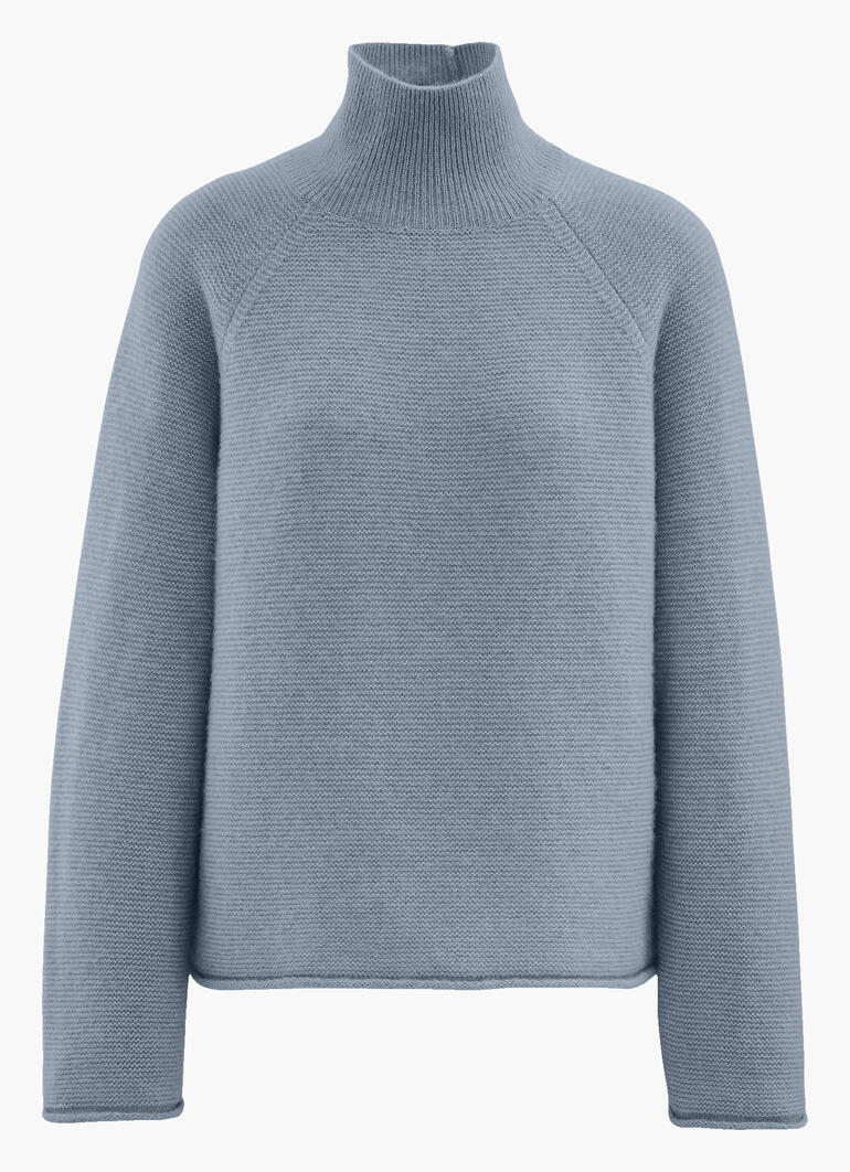Hellblauer Boxy-Pullover mit hohem Kragen.